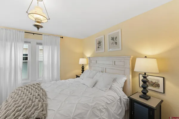 a bedroom with a bed and a chandelier