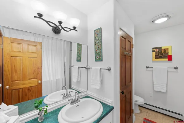 a bathroom with a sink a toilet and mirror