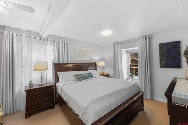 a bedroom with a bed a mirror and a window