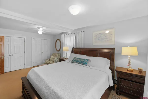 a bedroom with a bed and a lamp on dresser