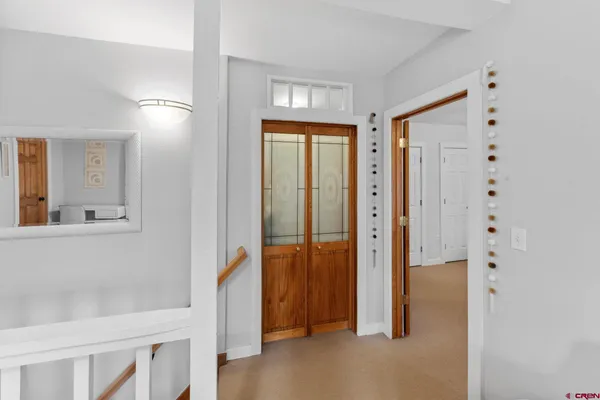 a view of a hallway with wooden floor and closet area