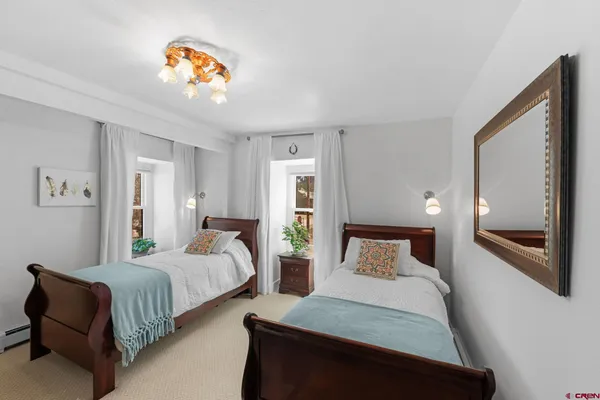 a bedroom with two beds and painting on the wall