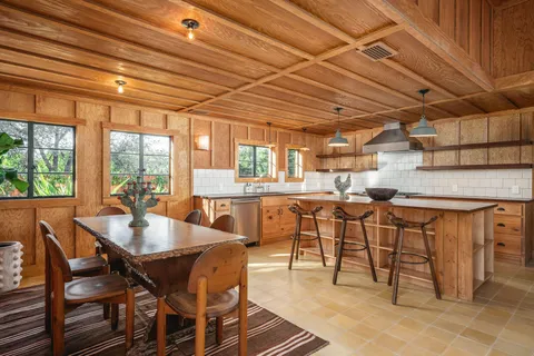 a dining room with furniture and a floor to ceiling window