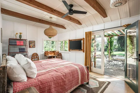 a bedroom with a bed large window with the outer view