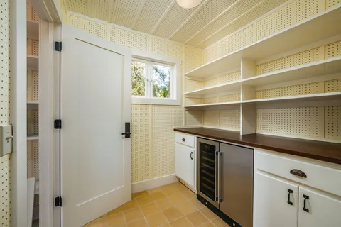 a kitchen with white cabinets and a refrigerator