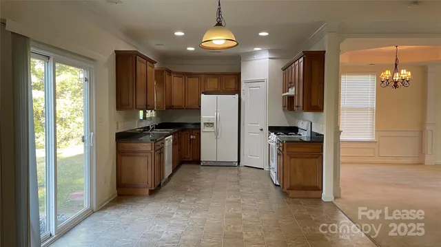 a kitchen with a refrigerator a stove top oven and a sink