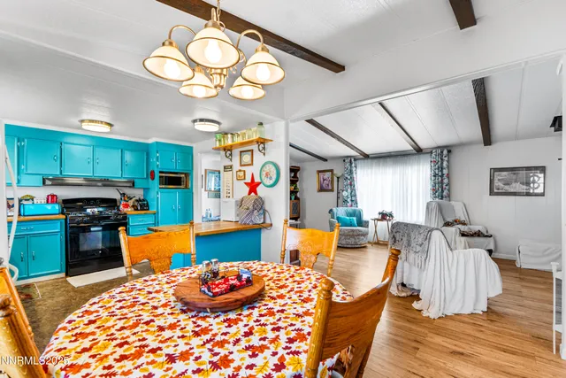 a living room with furniture kitchen view and a chandelier