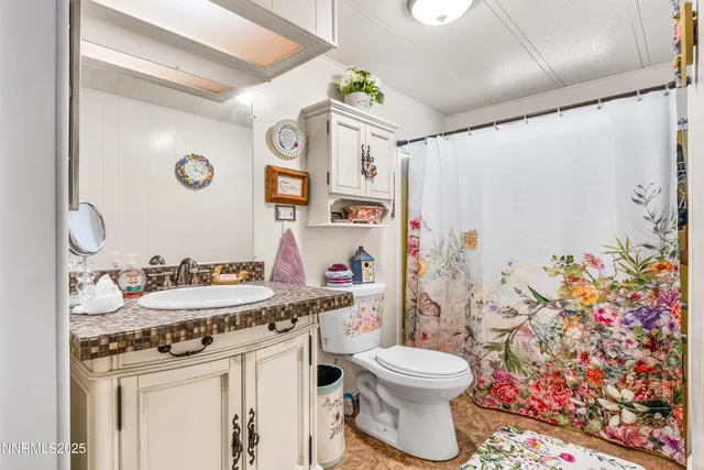 a bathroom with a granite countertop toilet sink and mirror