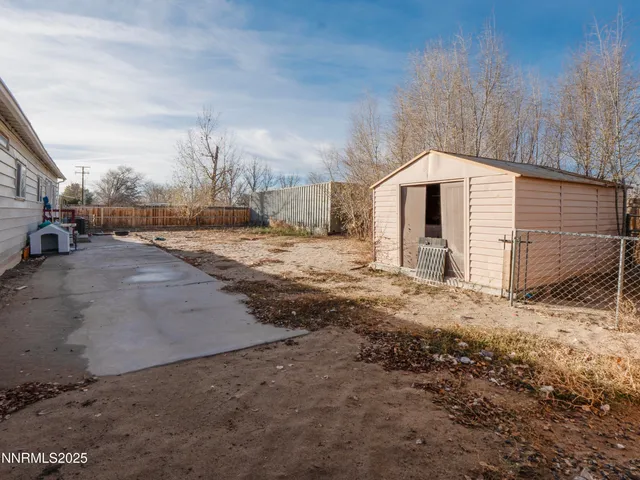 a large white house with a yard and wooden fence