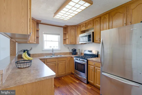 a kitchen with wooden cabinets and stainless steel appliances