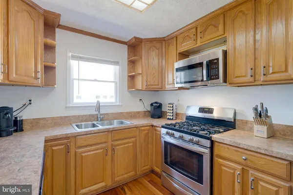 a kitchen with stainless steel appliances granite countertop a sink stove and microwave
