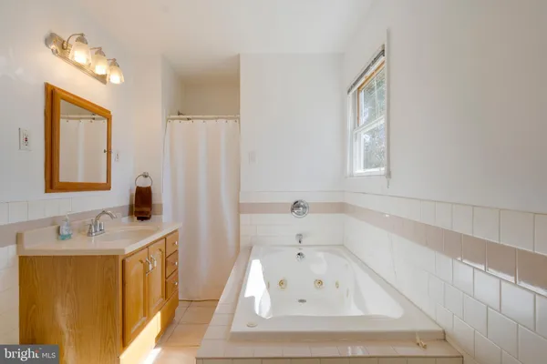 a bathroom with a tub sink and mirror