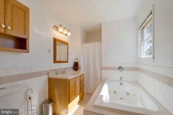 a bathroom with a sink a bathtub and a window