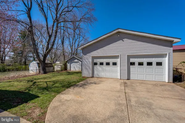 a front view of a house with a garden and trees