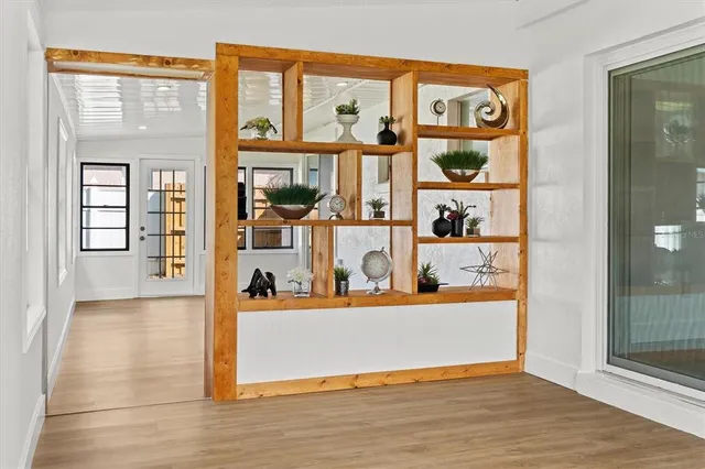 an empty room with wooden floor closet and windows