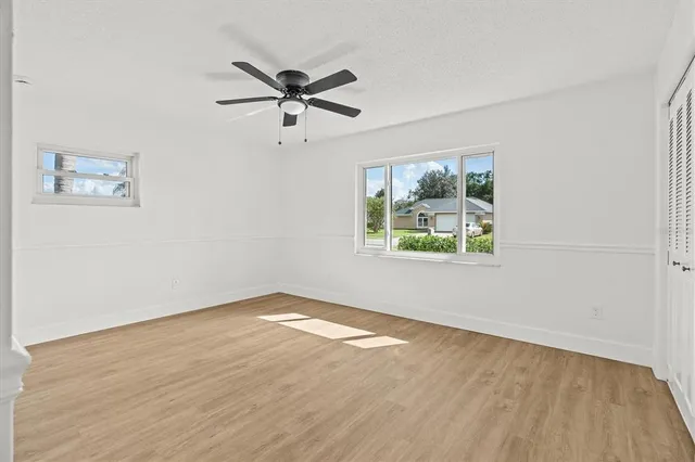 an aerial view of residential houses with outdoor space and trees