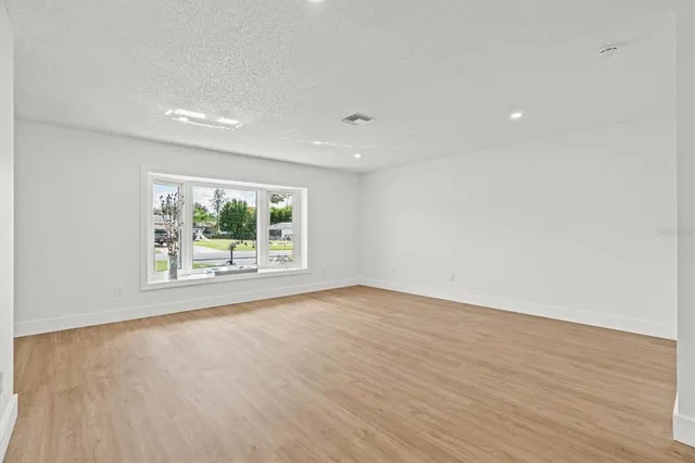 a kitchen with kitchen island white cabinets and wooden floor