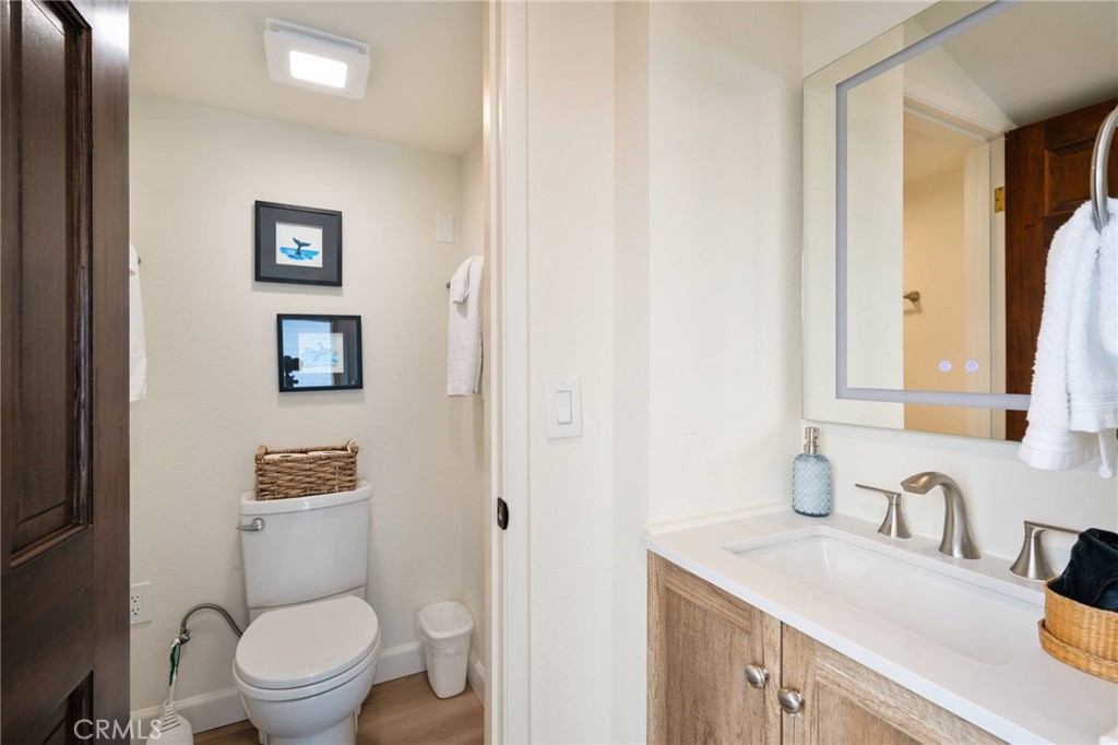 4865 Windsor Boulevard Cambria, CA 93428 - Photo 12 of 45 a bathroom with a granite countertop toilet sink and mirror