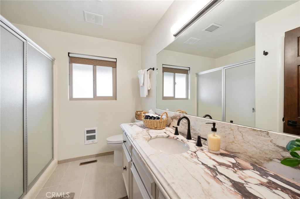 4865 Windsor Boulevard Cambria, CA 93428 - Photo 15 of 45 a bathroom with double vanity sinks a mirror and a shower