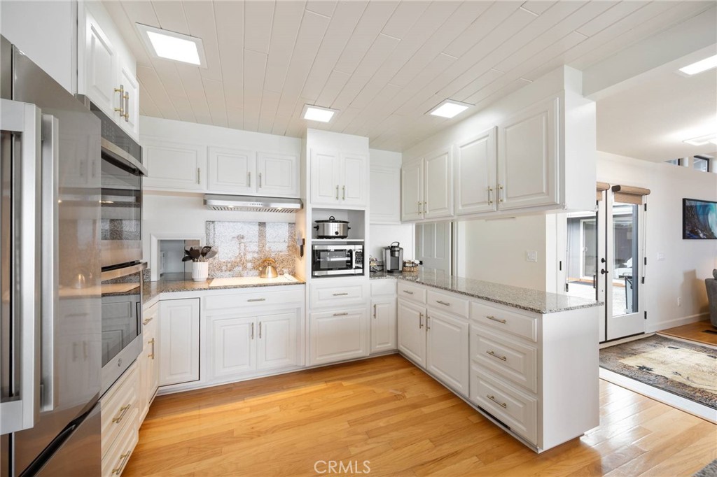 4865 Windsor Boulevard Cambria, CA 93428 - Photo 18 of 45 a kitchen with white cabinets and refrigerator