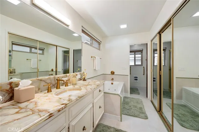 a bathroom with a granite countertop toilet sink and mirror