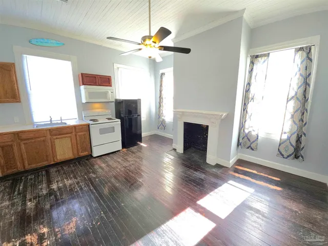 a room with chandelier fan and wooden floor