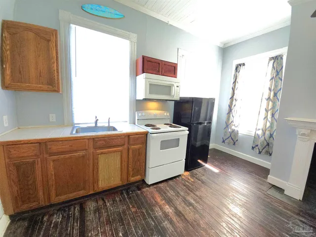a kitchen with granite countertop white cabinets and white appliances