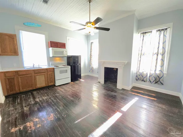 a view of a kitchen with a sink cabinet a fireplace and wooden floor