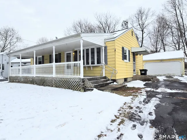 a front view of a house with a yard covered in snow