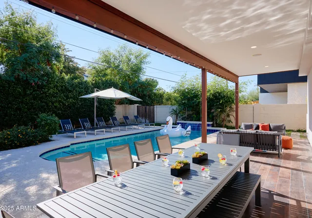 a view of a patio with couches table and chairs under an umbrella with a patio