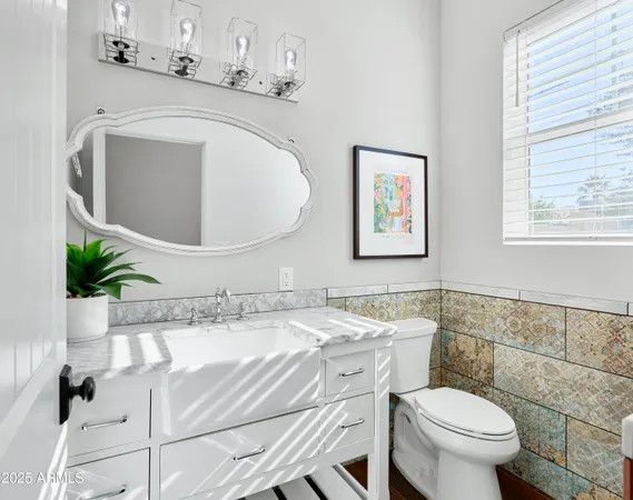 a bathroom with a granite countertop sink mirror vanity and toilet