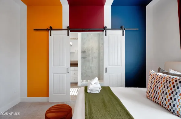 a bedroom with a bed and teddy bear on a dresser