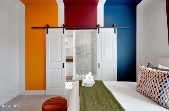 a bedroom with a bed and teddy bear on a dresser