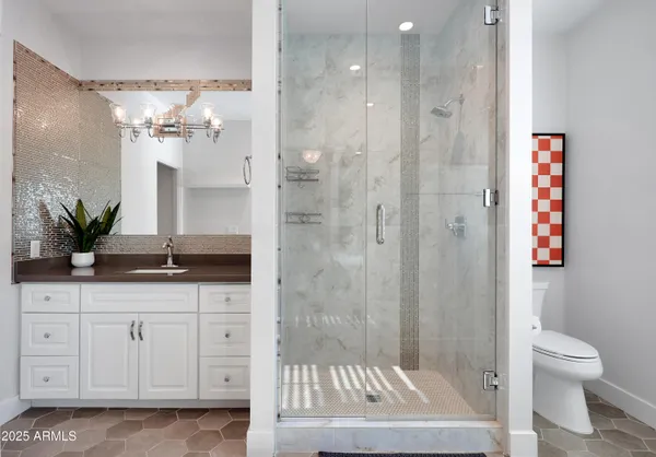 a bathroom with a granite countertop sink a toilet and a shower