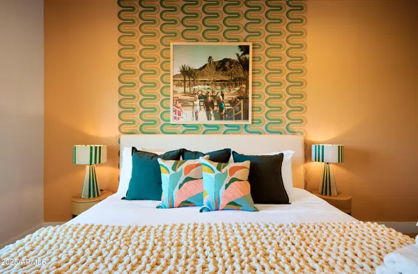 a bedroom with a bed and painting on the wall