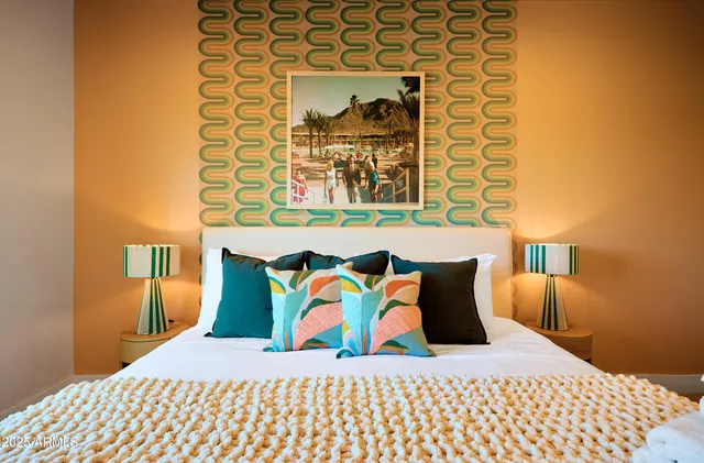 a bedroom with a bed and painting on the wall