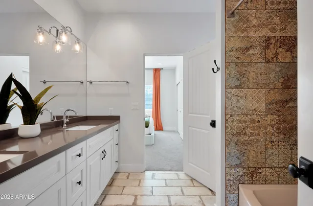 a bathroom with a granite countertop sink a mirror and shower