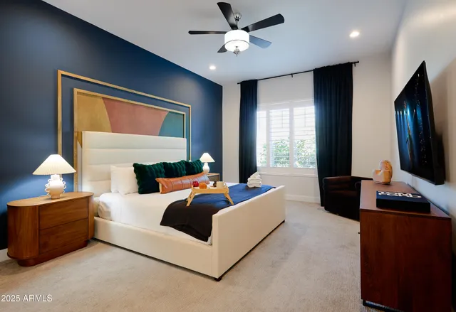 a bedroom with a large bed and a flat tv screen