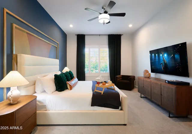 a bedroom with a bed window and a flat screen tv