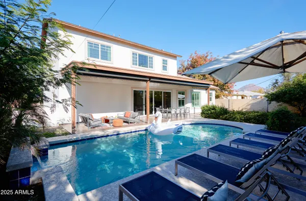 a view of a house with swimming pool and sitting area