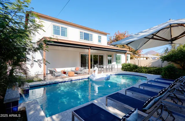 a view of a house with swimming pool and sitting area