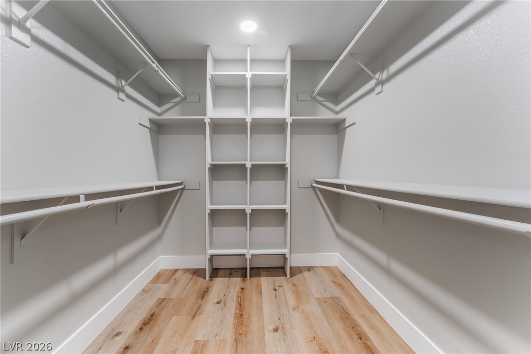 9171 West Viking Road Las Vegas, NV 89147 - Photo 36 of 43 Custom built-in shelving and ample hanging rods provide organized storage in this well-lit walk-in closet.