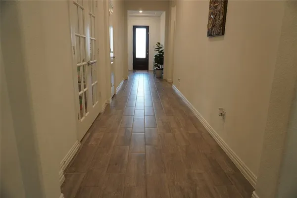 a view of a hallway with wooden floor