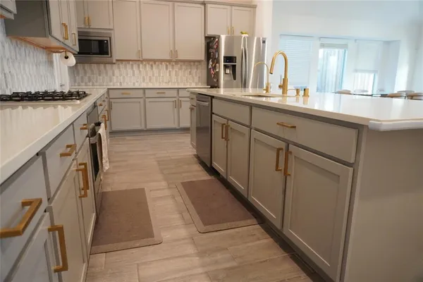 a kitchen with a sink cabinets and appliances