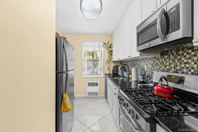 a kitchen with stainless steel appliances a stove a sink a refrigerator and cabinets