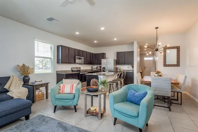 a living room with furniture and a view of kitchen