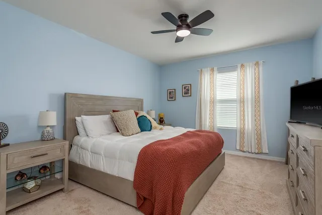 a bedroom with a bed and a flat tv screen on a dresser
