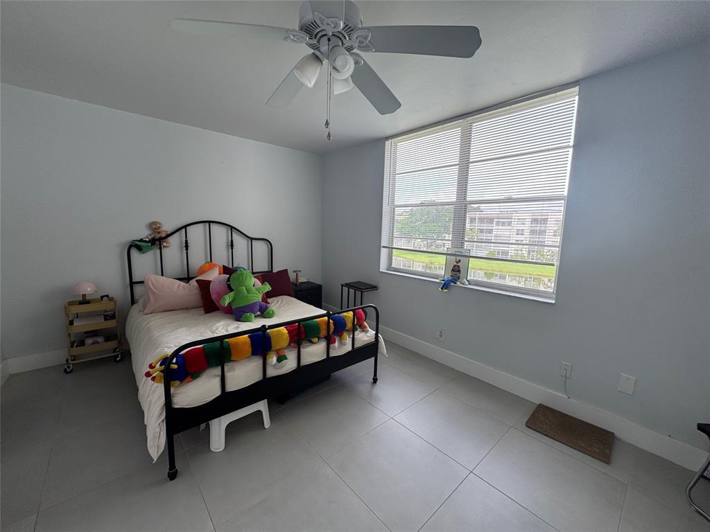 9235 A Lagoon Place, Unit 310 Davie, FL 33324 - Photo 13 of 32 a bedroom with a bed table and window