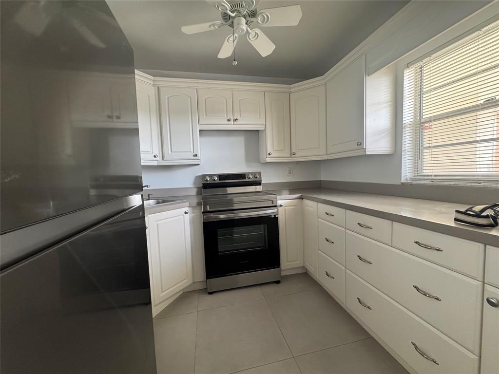 9235 A Lagoon Place, Unit 310 Davie, FL 33324 - Photo 3 of 32 a kitchen with white cabinets and white appliances