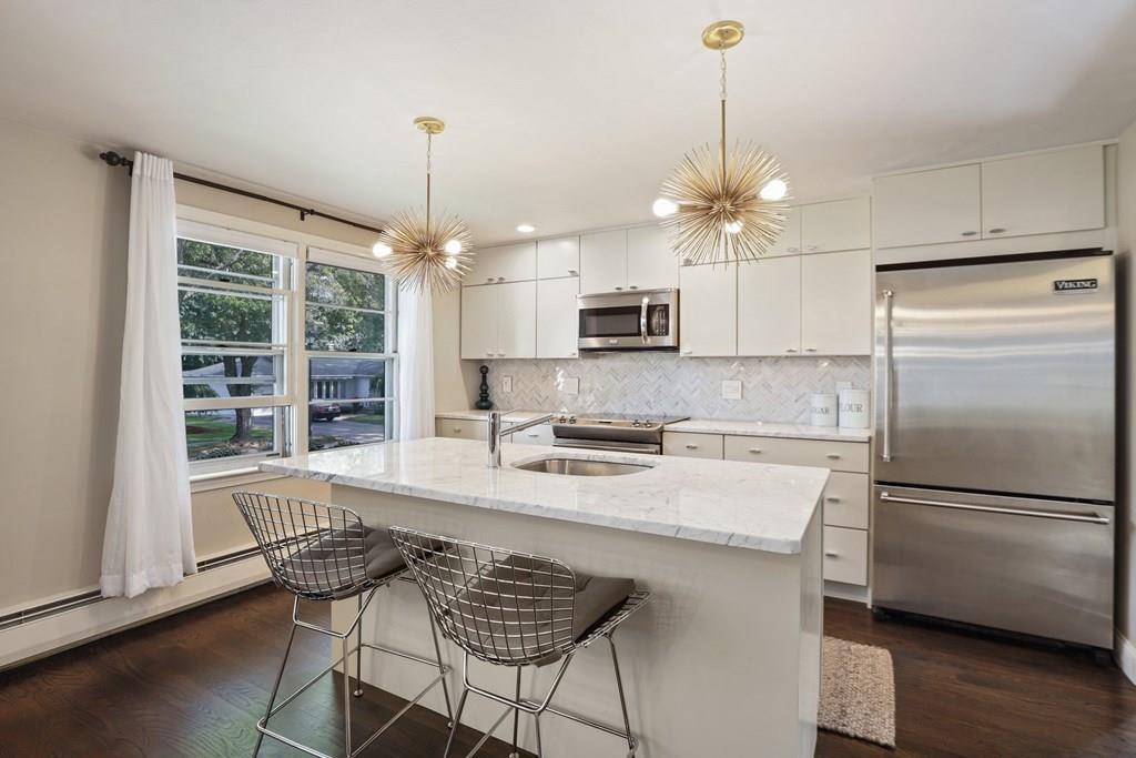 15 Herbert Road Worcester, MA 01602 - Photo 14 of 42 a kitchen with kitchen island a large counter top space appliances and a chandelier